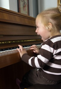 Kind musiziert auf einem Klavier