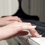 Detail of teenager hands playing the piano