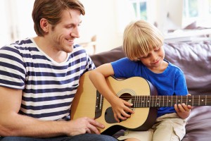 Father Teaching Son To Play Guitar